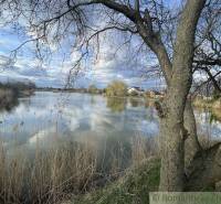 Lake in Tvrdošovce with a view of nature and houses in the background.