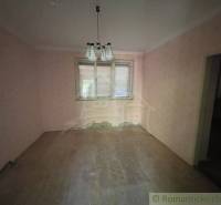 A room in a family house with pink walls and a wooden decor floor.
