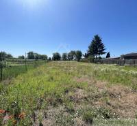 A plot of land near a family house in Tvrdošovce with fencing and greenery.