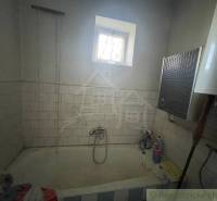 A bathroom in a family house with tiles on the walls and an old bathtub.