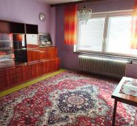 Purple walls and a luxurious chandelier adorn the room in the family house with a striking carpet.