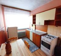 A kitchen in a family house with a wooden floor decor, a gas stove, a dining table.