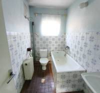 A bathroom in a family house with tiles and a bathtub, featuring characteristic patterned tiles.