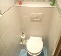 A bathroom with white tiles and a blue floor in a 2-room apartment.