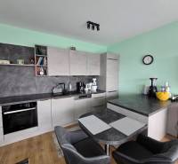 A kitchen with a dining table and a wooden decor floor in a Holiday Apartment.