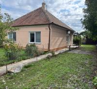 Family house in Komárno with a grassy garden and trees on a landscaped plot.