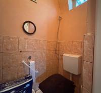 A bathroom with tiles, a mirror, and ventilation in a family house.