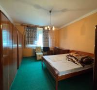 Bedroom in a family house with carpet and wooden furniture.