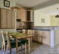 Dining area with wooden furniture next to the kitchen in a 3-room apartment.