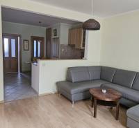 Living room with a corner sofa and a wooden decor floor in a 3-room apartment.