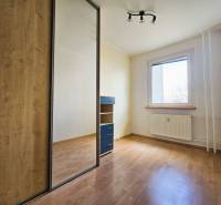 A room in a 3-room apartment with a wooden decor floor and a built-in wardrobe.