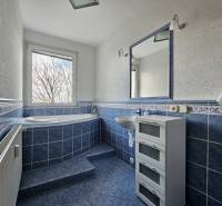 A bathroom with blue tiles and a large bathtub in a 3-room apartment.