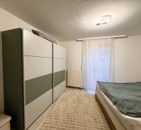 Bedroom in a 3-room apartment with a wardrobe, bed, and floor with wooden decor.