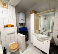 Bathroom in a 3-room apartment with white tiles, a washing machine, and a sink.