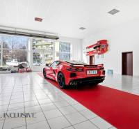 A red sports car on parquet flooring with wooden decor in commercial premises.