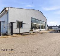 Commercial premises in Štúrovo with a gray facade, parking, and a shelter.