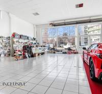 Auto service commercial premises with glass and a displayed car on the tiles, parts on the walls.