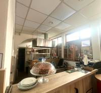 Interior of a gastro space with a wooden decor floor, counter, dessert, and plates.