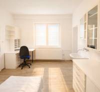 Offices with wood-patterned flooring, a desk, a sink, and cabinets.