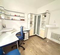 Office with a desk, shelves, and a wooden decor floor.
