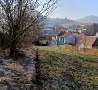 Landscape in Sklabina with residential plots, houses, and trees in the background.