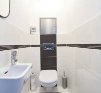 A bathroom with white tiles and sanitary ware in a 3-room apartment.