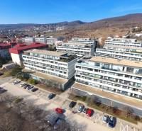 Apartment buildings on Pri vinohradoch Street in Bratislava - Rača surrounded by greenery and hills.
