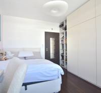 A bedroom with a built-in wardrobe, a wooden decor floor, and artwork. A 3-room apartment.