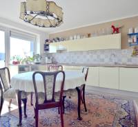 A kitchen in a 3-room apartment with a round table, carpets, and a decorative chandelier.
