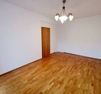 A room with a wooden decor floor and a light fixture in a 4-room apartment.