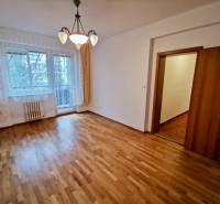 A room in a 4-room apartment with a wooden decor floor and curtains.