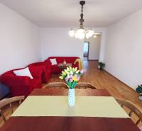 4-room apartment with red seating, dining table, and floor with wood decor.