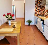 A kitchen area with tiles and a dining table with a vase in a 4-room apartment.