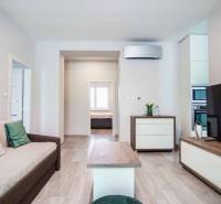 Living room in a 3-room apartment with a wooden decor floor and a comfortable sofa.