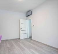 Interior with white walls, wood-patterned flooring, and simple furniture in a 3-room apartment.