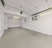 Spacious garage in a family house with tiles and white walls.