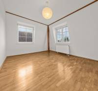 A room in a family house with white walls and a wooden decor floor.