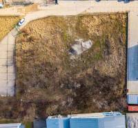 Aerial view of overgrown commercial land in Bratislava - Vajnory with adjacent buildings.