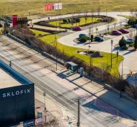 Commercial land in Bratislava-Vajnory with parking and greenery, adjacent to a cycling path.