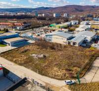 Aerial view of commercial land in Bratislava-Vajnory, surrounded by industrial buildings and greenery.