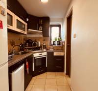 A kitchen in a 3-room apartment with a corner unit, a stove, and a tiled floor.