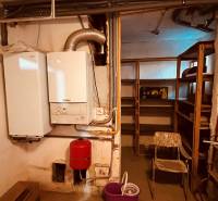 Boiler room with a boiler and shelves in the basement of a 3-room apartment.