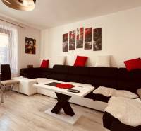 Living room in a three-room apartment, with a sofa and a wooden decor floor.