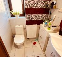 A bathroom with a toilet in a 3-room apartment, featuring white sanitary ware and decorative tiles.