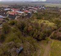 Aerial view of a village with houses and gardens surrounding the recreational grounds of Gemerské Teplice.