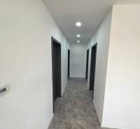 A hallway in a family house with dark doors and floor lighting with a wooden decor.