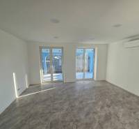 A spacious room with tiled flooring and glass doors in a family house.