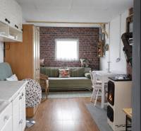 Living room with wood-patterned flooring and brick cladding, Gardens.