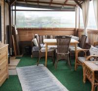 Gardens with rattan furniture, green carpet, and wooden decor.