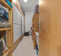 Storage space in a 4-room apartment with shelves full of household items.